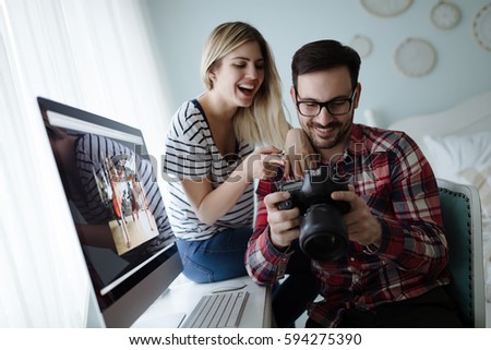 Photographer and beautiful female looking at photos on camera