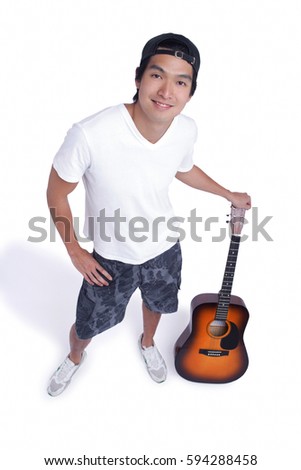 A man holds a guitar and smiles at the camera