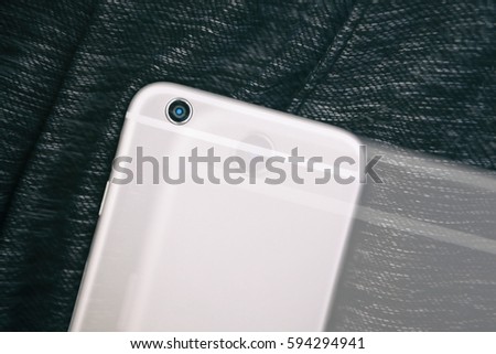 Big new silver smartphone on dark cloth.Modern smart phone model to stay always connected and take good pictures.Focus on camera lens.Double exposure