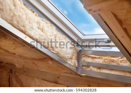 Plastic (mansard) or skylight window on attic with environmentally friendly and energy efficient thermal insulation rockwool. Royalty-Free Stock Photo #594302828