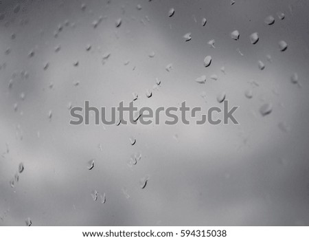 Drops of rain on a window glass.Through the window view of the sea and overcast clouds