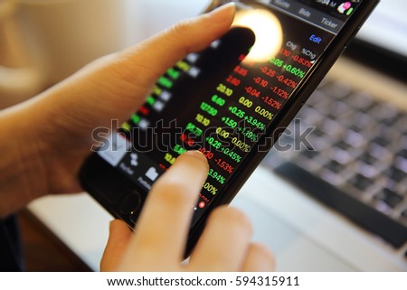 trading online on smartphone and notebook with business woman hand 