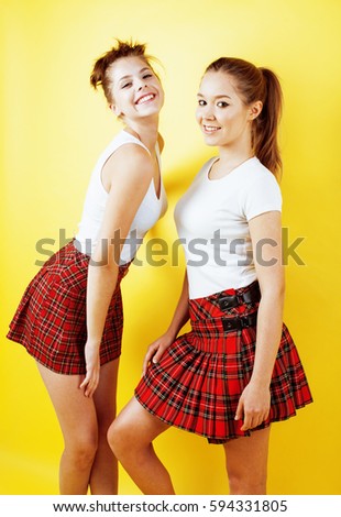 best friends teenage school girls together having fun, posing emotional on yellow background, besties happy smiling, lifestyle people concept