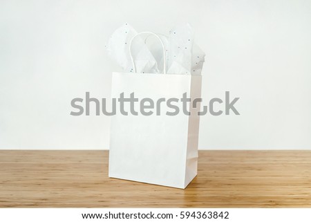 Mock-up of white blank craft package, White paper shopping bag with handles on wooden table in the white background
