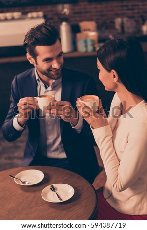 Happy romantic man and woman  sitting in a cafe drinking coffee Royalty-Free Stock Photo #594387719