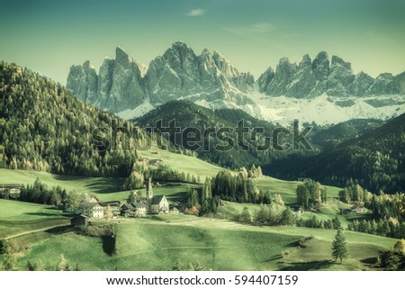 Vintage landscape with mountains and village in valley, film filter