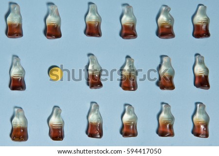 Top view picture of a lot of sweeties chewing candy in bottle form over blue table background.