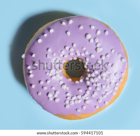 Top view photo of one colorful sweeties donut over blue table background.