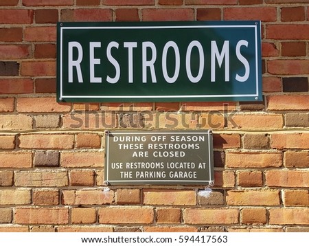 restrooms sign on brick wall