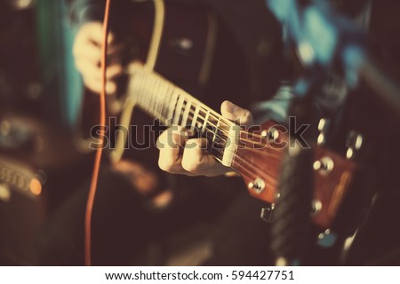 A guy playing an acoustic guitar. Fragment. Focus on the hand Royalty-Free Stock Photo #594427751