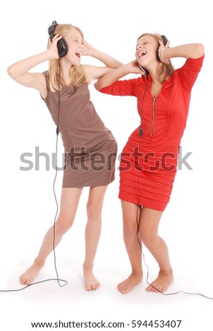 Two pretty teenage girls listening music on her headphones isolated on white background