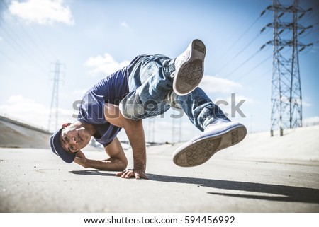 Bboy doing some stunts - Street artist breakdancing outdoors Royalty-Free Stock Photo #594456992