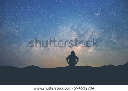 Long exposure Man standing along the waters edge under the Milky Way galaxy 