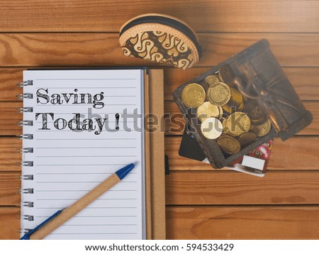 Business Concept. A box of coins, small purse and note book over the wood written SAVING TODAY.