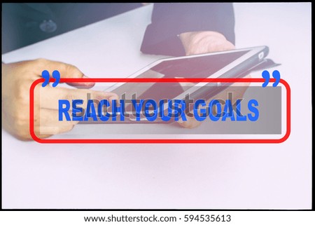Hand and text  "REACH YOUR GOALS" with vintage background. Technology concept.
