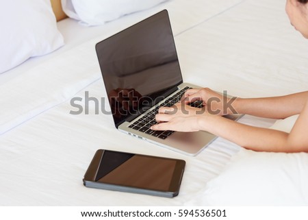 Young asian girl search data with laptop on bed.