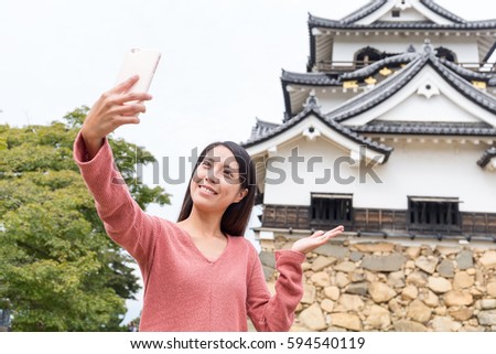 Woman taking selfie on mobile phone in hikone castle