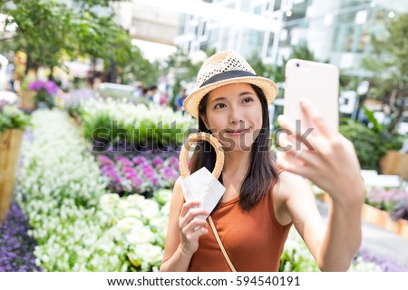 Woman holding Spanish churro to take selfie by cellphone
