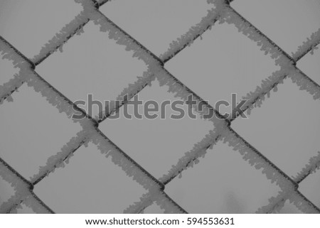 metal fence covered with snow, separated worlds, monochrome, black and white 