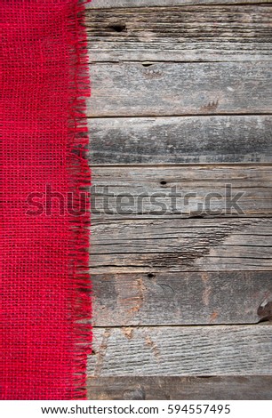 frayed red burlap border on weathered wood