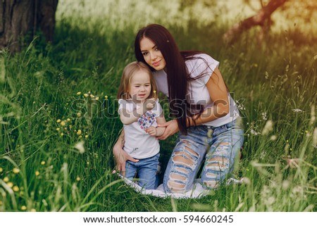 girl with her mom on  picnic at the tree in summer