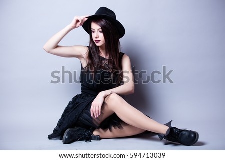 beautiful young woman sitting in front of wonderful white studio background