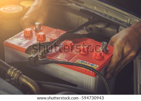 A car mechanic replaces a battery / soft focus picture 