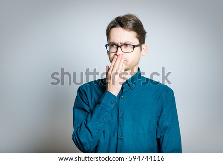 Business man squeamish, wears glasses, is isolated on a gray background