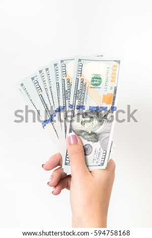 Closeup of one female caucasian hand holding many dollars isolated on white background. Vertical color photography.