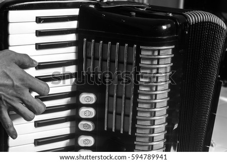closeup hand accordion player in black and white