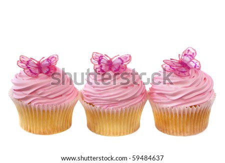 Three vanilla cupcakes decorated with pink frosting and little butterflies.  Isolated on white.