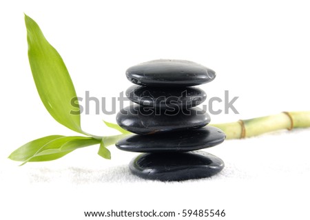 Stacked of black stones with bamboo leaf