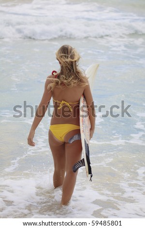 blond girl in a yellow bikini with her surfboard