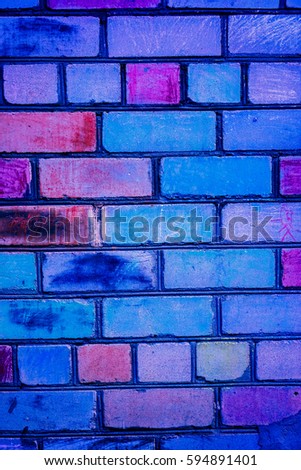 mistery light on bricks painted to rainbow color on brickwall. Colorful brick wall pattern, painted bricks as urban texture. Children painted brick wall to different colors. Brickwall as children art