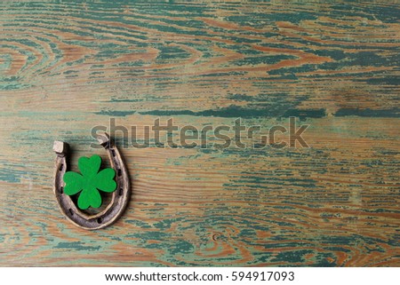 St. Patricks day, lucky charms. Horesechoe and shamrock on wooden background