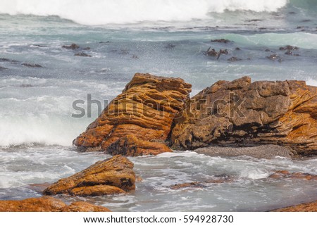 Waves crashing against the rocks along the shoreline of the Atlantic Ocean in the Cape Point nature reserve south of the city of Cape Town, South Africa
