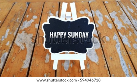 Business Concept - Chalk board with inscription HAPPY SUNDAY on a wooden table.  