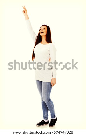 Smiling young woman shows something