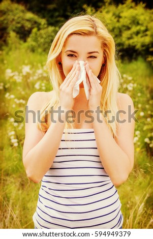 Girl with alergy blowing her nose.