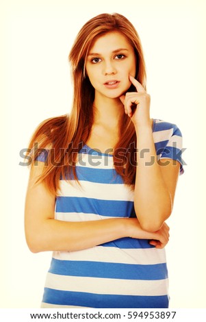 Pensive teenage woman with finger on cheek