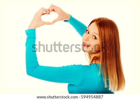 Smiling teenage woman making heart shape