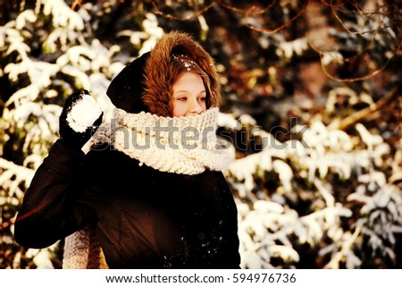 Young woman throwing snowball