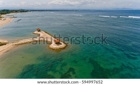 A beautiful view of the artificial island in the Bay of Sanur with two gazebos for rest. Aerial view. Sanur, Bali, Indonesia.