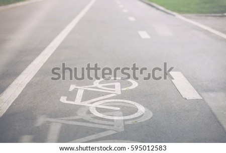 Bicycle lane in park. Separate way for riding ecological and healthy transport in the city. Sign of bike painter with white paint on asphalt.Double exposure