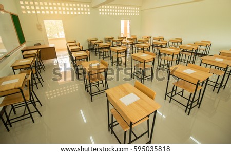 Empty of  School classroom with test exam paper on desks chair wood, and blackboard at high school Thailand, education concept Royalty-Free Stock Photo #595035818