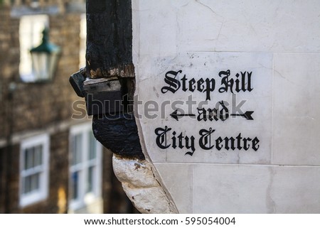 A traditional painted sign directing pedestrians to Steep Hill and the City Centre in the historic city of Lincoln in the UK.