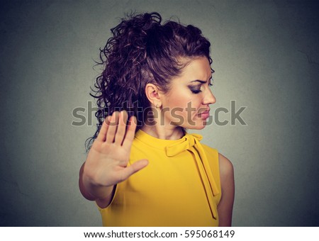 Closeup portrait annoyed angry woman with bad attitude giving talk to hand gesture with palm outward isolated gray wall background. Negative human emotion face expression feeling body language Royalty-Free Stock Photo #595068149