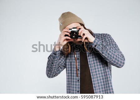 Hipster which making photo on retro camera. Isolated gray background