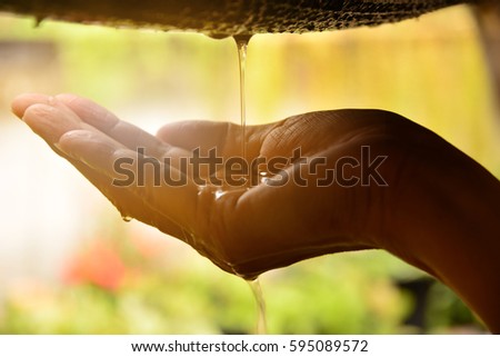 Water drop in to the hand of woman and flare light on hand  