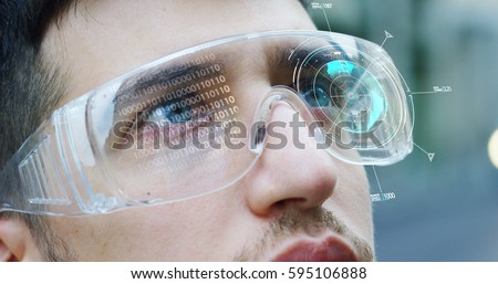 A man watches with a futuristic look with glasses augmented reality in holography. Concept: immersive technology, future, eyes, and futuristic vision.